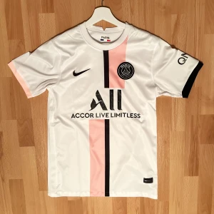 fotbollströjor - Snygg vit  fotbollströja från Nike med unikt blått ormmönster. Tröjan har korta ärmar och en rund halsringning med blå kant. Perfekt för fans som vill sticka ut på läktaren eller planen. Alla 3 för 800