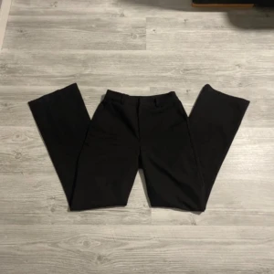 Svarta kostymbyxor från Bik Bok - Snygga svarta kostymbyxor från Bik Bok i klassisk design. Byxorna har en utsvängd passform med diskreta fickor bak och hällor för bälte, storlek xs/34, mycket bra skick, hör av dig vid frågor och kom gärna med prisförslag!💖