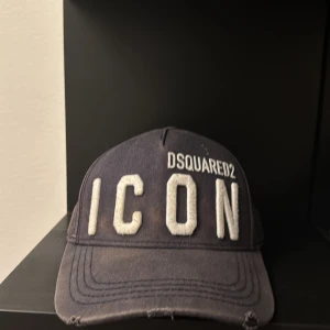Svart keps från Dsquared2 - Snygg svart keps från Dsquared2 med stor vit text 'ICON' framtill. Perfekt för en cool och avslappnad stil. Justerbar passform för optimal komfort.