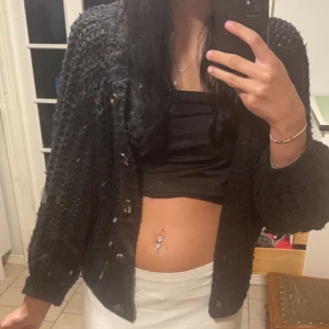 Svart stickad kofta från Pieces - Säljer en svart stickad kofta från Pieces med knappar framtill. Koftan har en fin struktur och är perfekt för lager-på-lager-stil. Passar bra till både jeans och kjol. Perfekt för kyligare dagar!