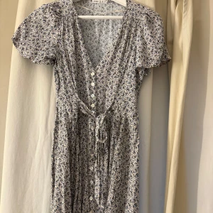 Klänning från oysho - Kort blommig klänning från oysho. Jättefin sommarklänning med knyte framtill. Helt oanvänd💕storlek xs