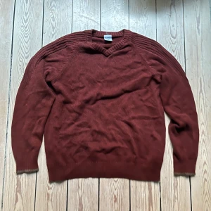 V-ringad Tröja  - En vinröd V-ringad tröja från Colombia sportswear. Medium passform, Storlek L. Gott skick! Mått: Längd 69cm, Bredd 55cm, Arm 74cm, Arm-nedåt 25cm. Möts på Södermalm, använd gärna "köp nu"