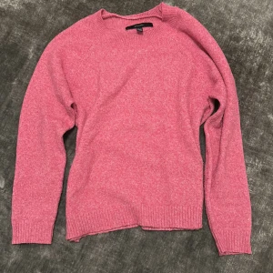 Rosa stickad tröja från Vero Moda - Säljer en mysig rosa stickad tröja från Vero Moda. Tröjan har långa ärmar och ribbstickade muddar vid ärmslut och nederkant. Perfekt för kyliga dagar!
