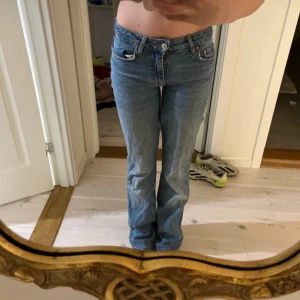 Lågmidjade flared jeans från Gina - Snygga flared jeans från Gina som jag sytt om själv med symaskin i en klassisk blå denim. De har en trendig utsvängd stil som ger en retro känsla. Perfekta för att skapa en avslappnad look med en modern twist.