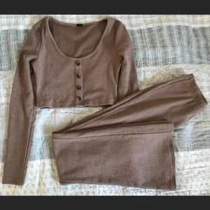 Brun ribbad croppad tröja - Säljer en brun ribbad croppad tröja med långa ärmar och knappar framtill. Perfekt för en avslappnad stil. Aldrig använd