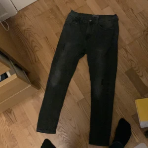 Svarta jeans från Zara Man - Snygga svarta jeans från Zara Man. De har snygga slitningar 2 där fram och en liten på bakfickan skick 9/10 säljer för bra pris. Priset är fast