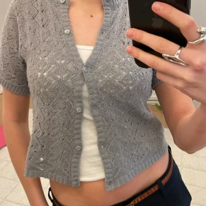 Grå stickad kofta - Säljer en söt grå stickad kofta med korta ärmar. Koftan är i barnstorlek men som ni ser passar den mig perfekt som är en xs/s! skriv om ni har frågor! 