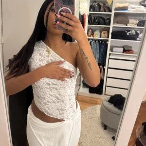 Vit spets topp - Säljer en elegant vit spets topp med öppen rygg och knytband. Lite genomskinlig! 