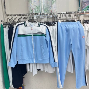 Casablanca tracksuit SJUK  - Snyggt ljusblått träningsset från Casablanca med dragkedja och gröna samt svarta ränder. Tröjan har långa ärmar och matchande byxor med elastisk midja. Perfekt för en sportig look!