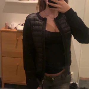 Svart moncler cardigan  - Säljer en stilren svart quiltad jacka från Moncler. Jackan har en dragkedja framtill och långa ärmar. Perfekt för kyligare dagar och ger en snygg look. Passar bra till både jeans och kjol. ⚠️⚠️Lånade bilder kontakta för egna bilder. Pris kan diskuteras 