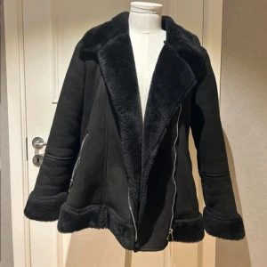 Svart pälsjacka med dragkedja - Snygg svart pälsjacka med fluffig krage