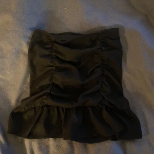 Svart kjol - Snygg svart kjol från Gina Tricot med volangdetaljer. Perfekt för en stilren look. Tillverkad i ett mjukt och bekvämt material.