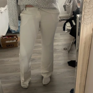 Vita kostymbyxor - Säljer dessa vita kostymbyxor som haft en slits vid foten som är ihopsydd! Från bikbok i storlek 42, passar en m.