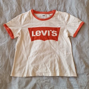 T-shirt från Levi's - Vit t-shirt från Levi's med orange logga på bröstet.