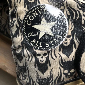 Unika Converse med dödskallemönster - Säljer ett par Converse All Star med unikt dödskallemönster i svart och beige. Skorna har klassisk snörning och en rund tå. Perfekta för dig som vill ha en ”edgy” stil. ———————Mycket väl använda- köpta second hand typ 2013 och sedan fortsatt använda rikligt. Snörningen lite trasigt samt skav på insida häl och missfärgning där det troligtvis förr varit vit färg, som nu är beige. ————————————— Väldigt unika men också stort slitage - därav priset! 
