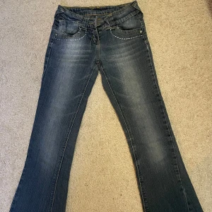 Blå jeans med broderade detaljer - Snygga blå jeans med broderade detaljer på bakfickorna och en klassisk femficksdesign. De har en lätt utsvängd bootcut-stil och en lågmidjad passform. Tyvärr för små för mig!