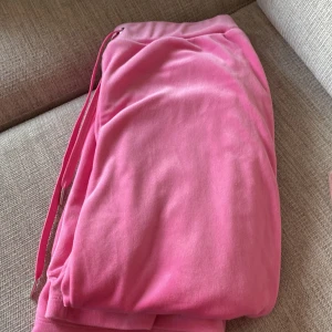 Rosa mjukisbyxor från Gina Tricot - Säljer ett par rosa mjukisbyxor från Gina Tricot i storlek XS. Byxorna har en bekväm passform med dragsko i midjan för justerbarhet. Perfekta för en avslappnad stil.