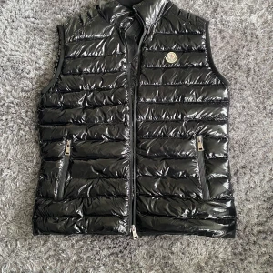 Moncler väst - Tja, säljer denna moncler väst då den inte riktigt sitter som jag vill. Storlek: M.  Hör av dig för fler bilder eller info