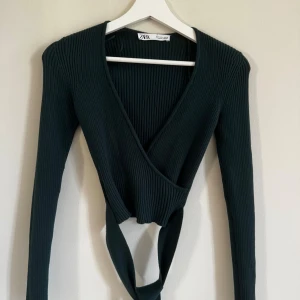 Grön tröja Zara - Använd ett fåtal gånger. Stickad grön långärmad tröja med rosett/band som går att knyta runt midjan. I fint skick. 