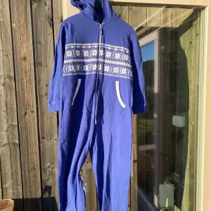 Säljer en supermysig blå onesie från Zoozi. Den har ett snyggt vitt mönster över bröstet och en praktisk dragkedja framtill. Perfekt för kalla dagar med sin långa ärmar och huva. Fickor på sidorna för extra bekvämlighet. Perfekt för att chilla hemma eller ha på sig på vintern! I mycket fint skick!