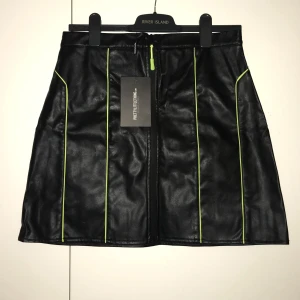 Svart och limegrön faux läderkjol - Jättesnygg fakeläderkjol, helt oanvänd. Från Pretty Young Thing/Asos. Prislapp kvar 💚