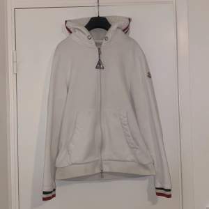 Fin vit moncler zip Hoodie i storlek M men passar som S. Säljer den för att den inte passar längre .Fint skick på den och Qr cod funkar .  Köpte den från Plick så vet inte om den är äkta.