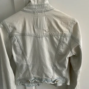 Jeansjacka från Gina Tricot  - Ljusblå jeansjacka från Gina Tricot med guldfärgade knappar. Mycket gott begagnat skick