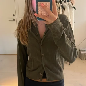 Hm kofta - Säljer denna super fina koftan från hm i en jötte fin mörk oliv grön färg!! Perfekt för hösten! Jättefint skick men knapp hålen är ”uttöjda”. Dom var det när jsg köpte den. Hör av dig om du vill ha fler bilder eller annan info!!