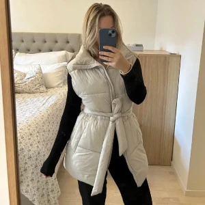 Begie lång väst - Säljer min långa väst pga aldrig använt den. Den är från hm men jag köpte den på plick. Färgen är kall begie. Perfekr väst till höst/ vintern☺️🩷sitter som s/m. (Dom två försha bilderna är lånade av hon jag köpte den av)