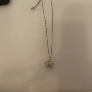 Silverhalsband med hjärthänge - Säljer ett elegant silverhalsband med ett fint hjärthänge. Perfekt för att ge en touch av stil till vilken outfit som helst. Kedjan är tunn och smidig, vilket gör den bekväm att bära hela dagen. Passar både till vardags och festliga tillfällen.