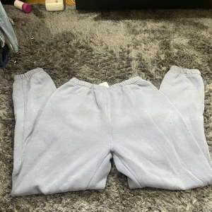 Grå mjukisbyxor från Basically Basics - Säljer ett par grå mjukisbyxor från Basically Basics i storlek M. De är superbekväma och perfekta för en chill dag hemma. Byxorna har en elastisk midja och är gjorda i ett mjukt material.