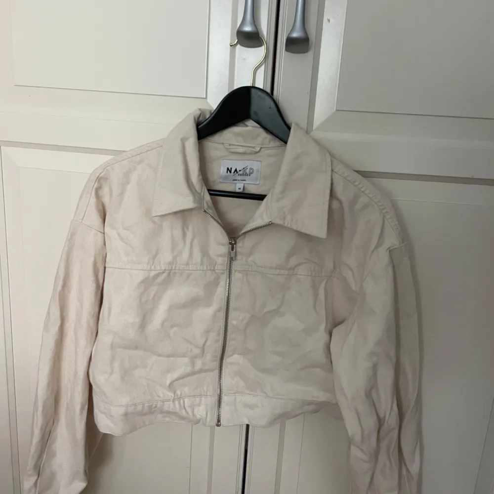 Snygg croppad ljus beige jeansjacka. Använd: 1 gång  Färg: ljus beige Mitt pris: 50kr Storlek: 40 men skulle säga att den passar 36/38 Märke: NA-KD. Jackor.