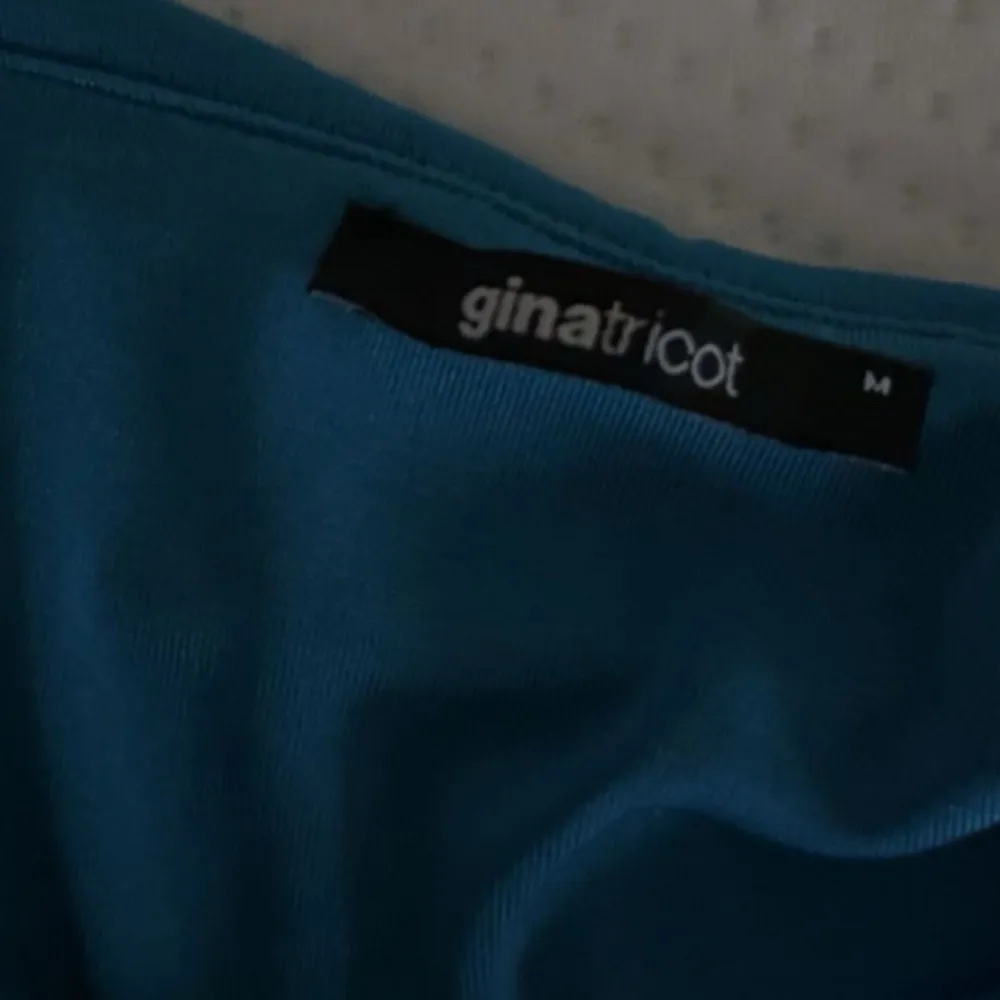 Säljer en snygg blå långärmad topp från Gina Tricot. Den har en unik off-shoulder design som ger en stilren look. Perfekt för både vardag och fest!. Yläosat.