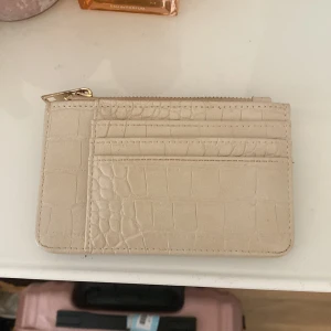 Plånbok  - Beige plånbok som inte kommit till användning på ett tag och som är i bra skick. 