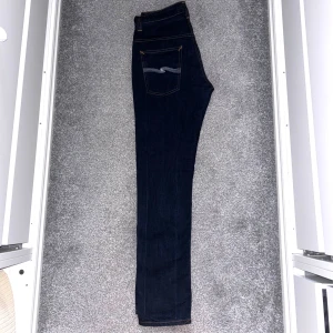 Nudie Jeans  - Ett par mörkblåa nudie jeans i storlek 32/32, sitter mer som 30/32 jeansen är i mycket bra skick Vi säljer för 399! Skriv vid frågor🤝