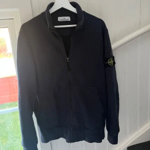 Stone Island fullzip - Riktigt snygg fullzip nu till hösten, storleken är L men passar även M. Köpt på NK galleria Stockholm. En liten skråma på framsidan som knappt syns. Pris kan absolut diskuteras vid affär, hör av dig vid några frågor!