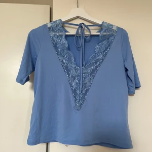 Blå blus  - Blå blus från Gina Tricot med spetsdetaljer i ryggen i storlek XS. Mycket bra skick