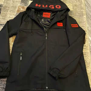 Hugo boss vind jacka  - Säljer en Hugo boss vind jacka oanvänd endast testad storlek M jätte skön på märket rött och själva jackan svart inga skador eller nått liknande köp en till Burberry vindjacka som finns i min profil för 1000