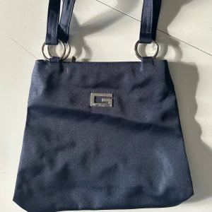 Marinblå handväska - Snygg handväska som man kan ha över axeln. Aldrig använd och i superbra skick!