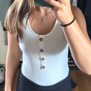 Ribbad body med knappar  - Säljer denna bodyn, knappt använd. Köparen står för frakten. 