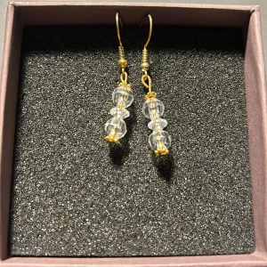 Örhängen med klara pärlor och gulddetaljer - Snygga örhängen med tre klara pärlor staplade på varandra och guldfärgade detaljer. Perfekta för att ge en elegant touch till vilken outfit som helst. De hänger fint och är lätta att bära hela dagen.💘