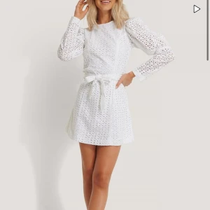 Vit spetsklänning med knytband - Säljer en superfin vit klänning i spets med långa ärmar och ett sött knytband i midjan. Klänningen har en öppen rygg och är perfekt för sommarens alla fester. Endast testad. 299kr ny