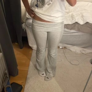 Grå mjukisbyxor - Säljer ett par superbekväma grå mjukisbyxor i bra skick. De är lågmidjade och har en bootcut-stil som ger en avslappnad look. Perfekta för mysiga hemmakvällar eller en chill dag ute. Passar perfekt till en t-shirt eller hoodie.
