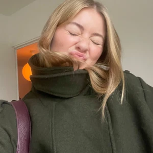 Mörkgrön kappa - Säljer en snygg mörkgrön kappa i ull. Perfekt för höst och vinter med hög krage. Skriv om du vill ha mer bilder! 