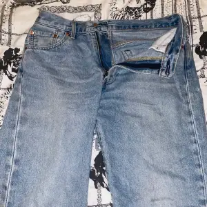 Säljer ett par klassiska Levis 1995 jeans i ljusblå denim. De har en dragkedja och knapp framtill samt fem fickor. Jeansen är i bra skick men har en liten reva vid grenen som jag har försökt laga. Perfekta för en avslappnad stil! W 30 L 32