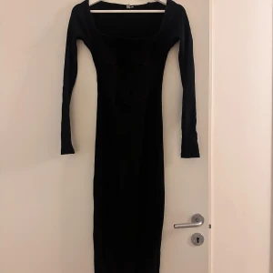 Svart långklänning - Snygg svart långklänning i ribbat material med långärm. Den är som i korsett model Klänningen är stilren och passar både till fest och vardag. 