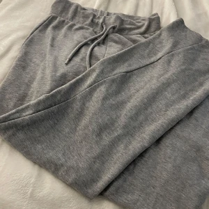 Grå mjukisbyxor med snörning - Superbekväma grå mjukisbyxor i bomull med snörning i midjan. Perfekta för en chill dag hemma eller en snabb tur till affären. De har en loose passform som gör dem extra mysiga. Ett måste för alla som älskar komfort! Säljer dom eftesom dom används inte
