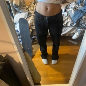 Svarta jeans från Wrangler - Säljer ett par svarta baggy low jeans från Wrangler i mycket bra skick. De har en liten reva på ena benet som ger dem en cool, sliten look vilket jag tycker ger en extra liten detalj i jeansen! Perfekta för en avslappnad stil. Skriv för mått :) pris kan diskuteras