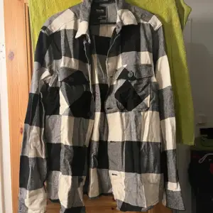 Säljer en snygg svartvit rutig overshirt från Only & Sons. Perfekt för höst och vår! Den har långa ärmar och knappar framtill samt två bröstfickor med knappar. Materialet känns mjukt och bekvämt, perfekt för lager-på-lager-stil. Passar både till vardags och lite mer uppklädda tillfällen. Endast provad ☺️