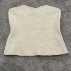 Vit ribbad tubtopp från & Other Stories - Säljer en stilren vit ribbad trendig tubtopp från & Other Stories. Toppen är i mycket bra skick förutom några enstaka noppror och har en tight passform som framhäver figuren. Passar både till vardags och festliga tillfällen. Är storlek l men passar m🥰